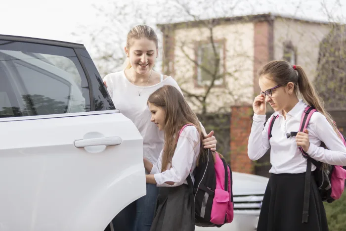 Two cute schoolgirls getting a safe Excel Taxi Yeovil car ride to school